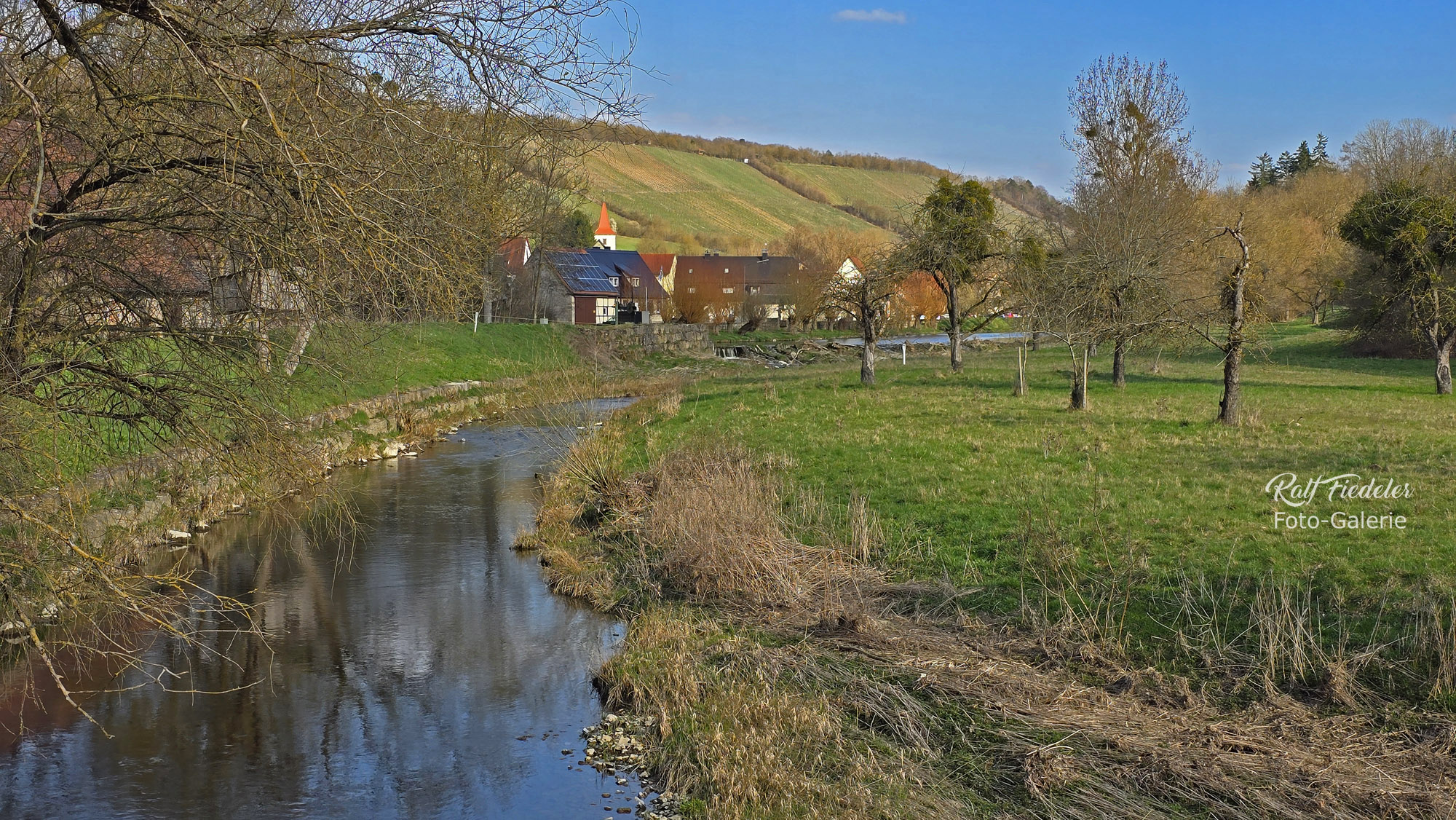 Tauber mit dem Dorf Tauberzell von der Holzbrücke am Ortsausgang aus